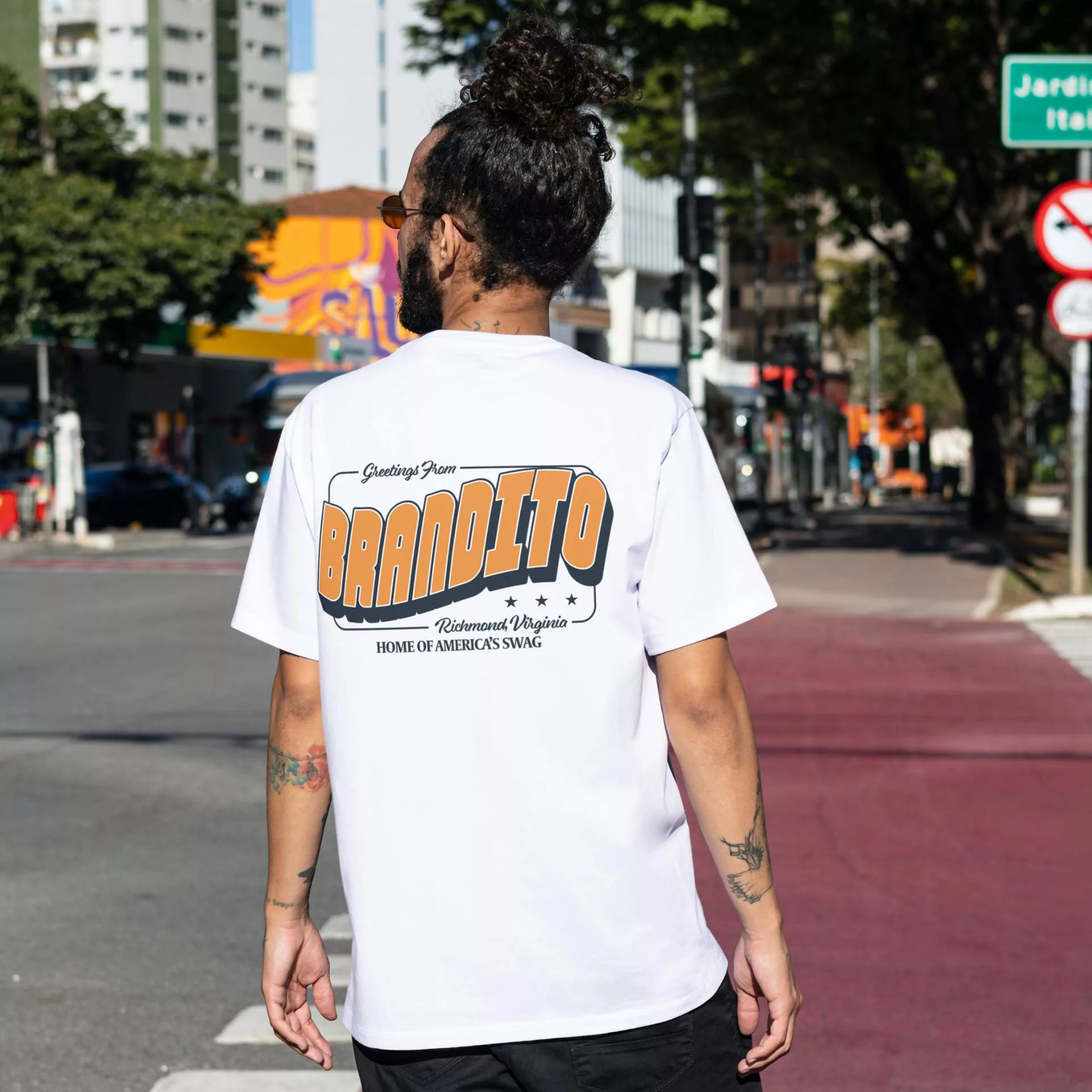 A person crossing the street wearing a Brandito shirt